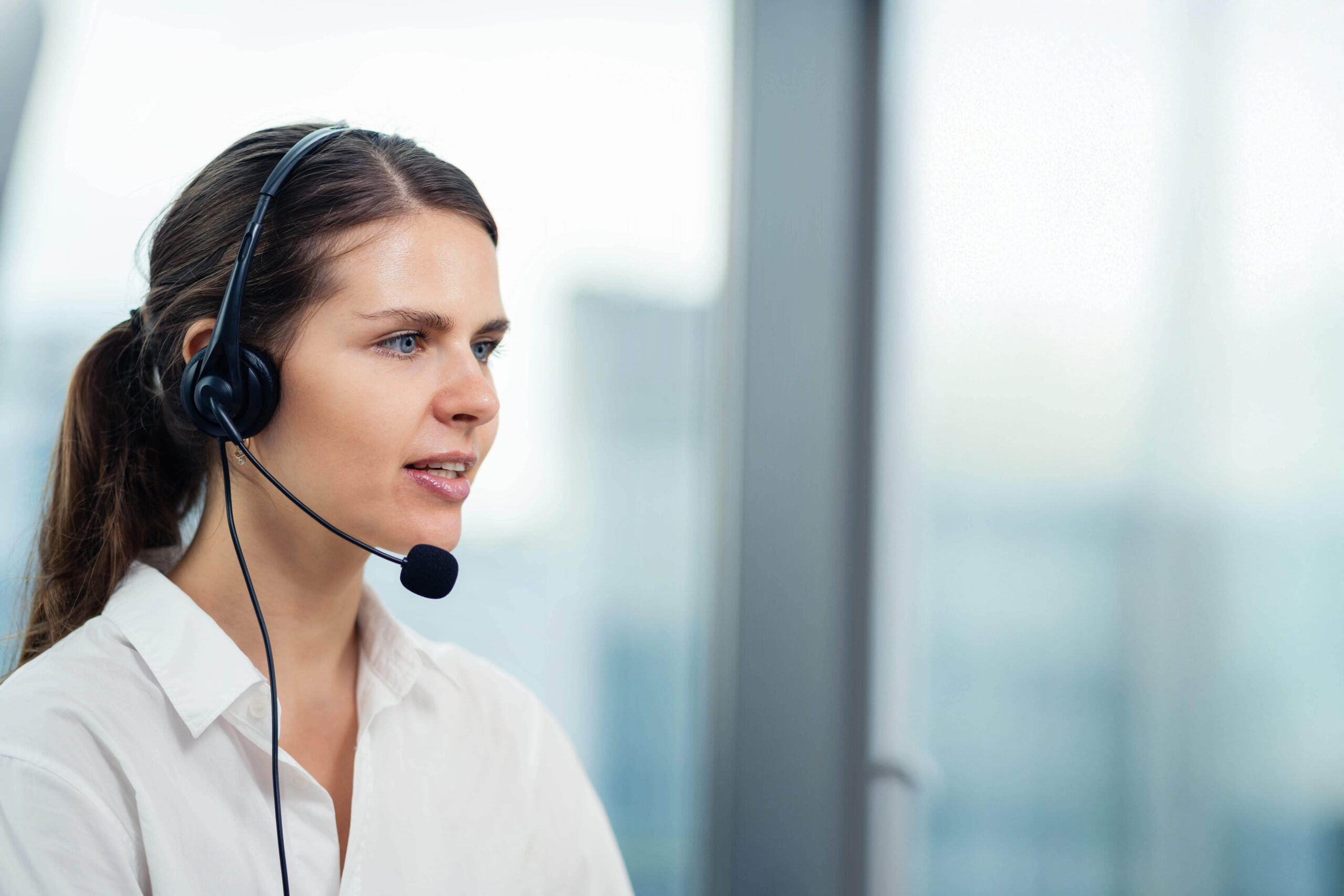 AdobeStock_533449344_KANGWANS_ret-tiny Frau mit Headset spricht konzentriert – Sinnbild für das Zuhören in der Telefonseelsorge.