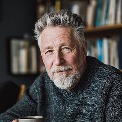 Ein älterer Mann mit grauem Bart und ruhigem Blick – vermittelt Lebenserfahrung und Zuversicht.