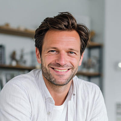 Ein Mann mittleren Alters schaut lächelnd in die Kamera.